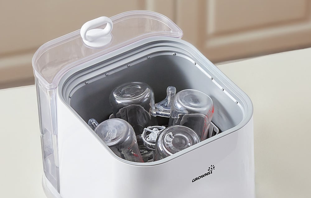 Close-up of the inside of the washer with bottles and pacifiers placed inside