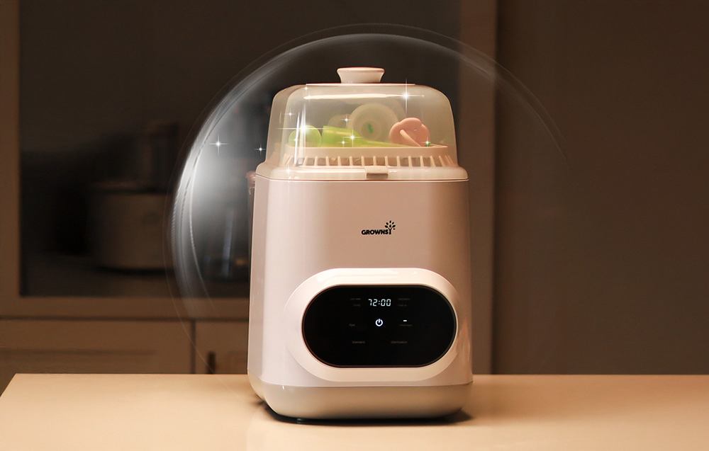 Bottle washer with a transparent lid and interior full of accessories, surrounded by a glossy effect