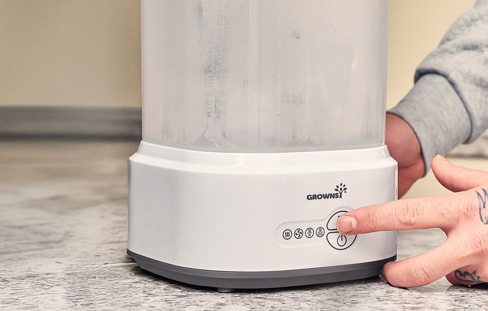 Close-up of a hand pressing the button of a sterilizer placed on the floor