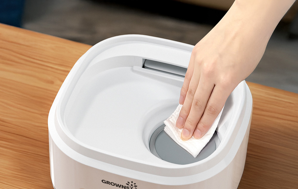 Hand wiping the inside of the sterilizer base with a cloth