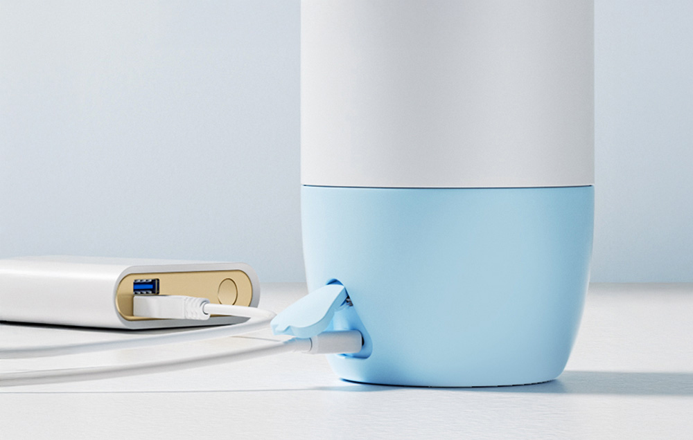 Close-up of the bottom of the warmer with a cable connected to a power bank